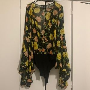 Sheer black with floral print wrap style body suit with voluminous sleeves.